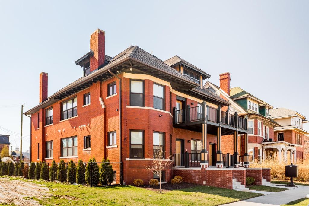 a large red brick building with a balcony at Mint House Detroit - Brush Park in Detroit