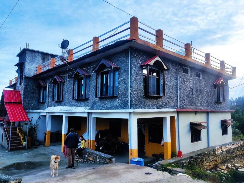 a man and a dog standing in front of a house at Shree Om Nanda Rudra Hotel Chaukori Pithoragarh in Chaukori
