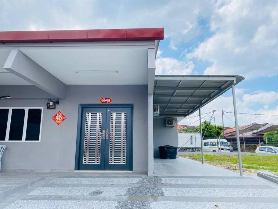 a gas station with a blue door and a red sign at A Cool place to stay in Seremban