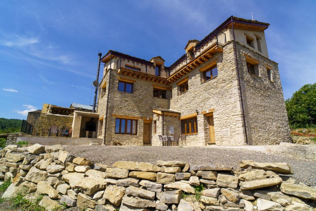 un antiguo castillo con una pared de piedra delante de él en Casa Barambán en Lasaosa