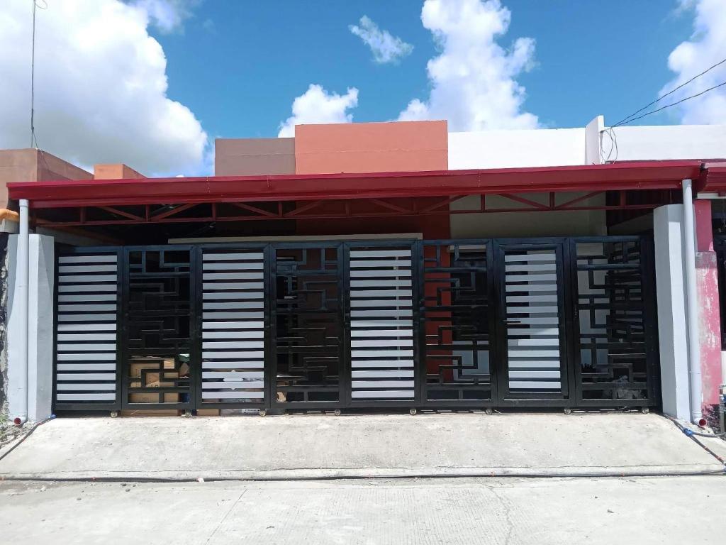 a building with black and white shutters on it at JILY’s Transient Tiny House in Bayugan City