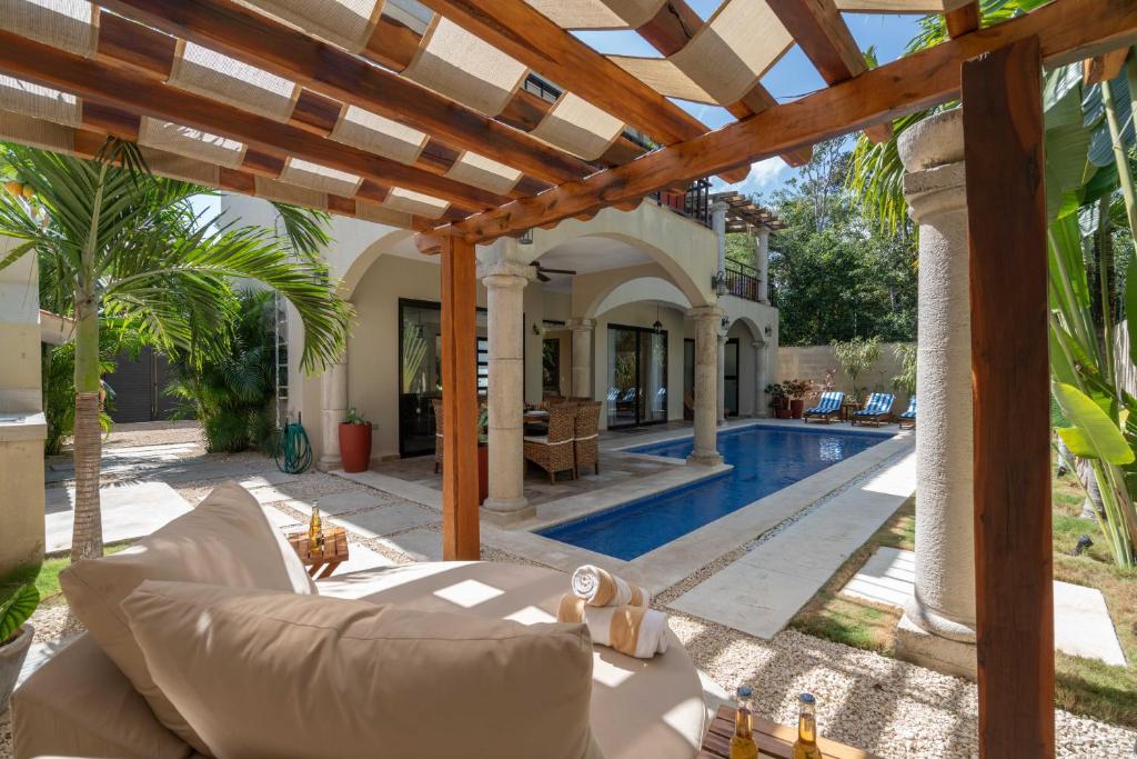 un salon extérieur avec une pergola et une piscine dans l'établissement Tulum Stunning Villa for 10-Cabana-Private Pool-Parking, à Tulum