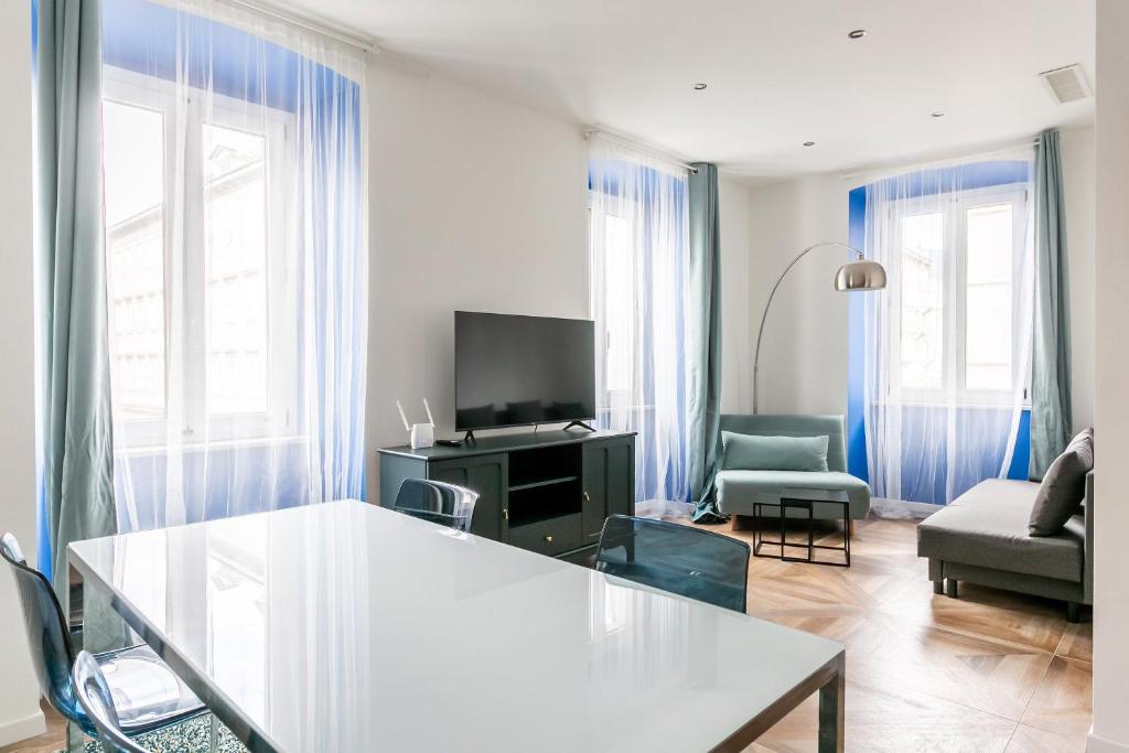 a living room with a table and a couch and a tv at Botique Apartment • Trieste City Center [Wifi] in Trieste