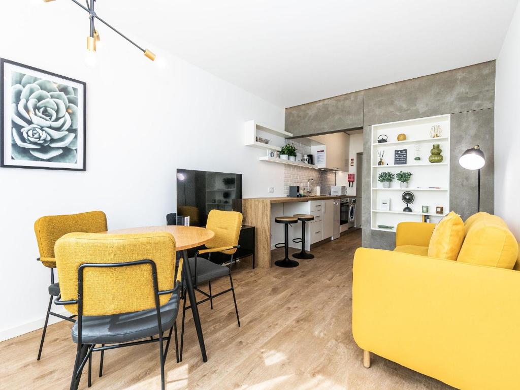 sala de estar con mesa y sillas amarillas en Apartamento Primavera, en Parede
