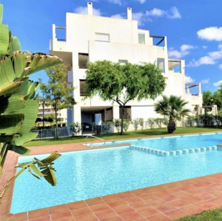 a swimming pool in front of a building at 2-Bed Penthouse Apartment in Roldán