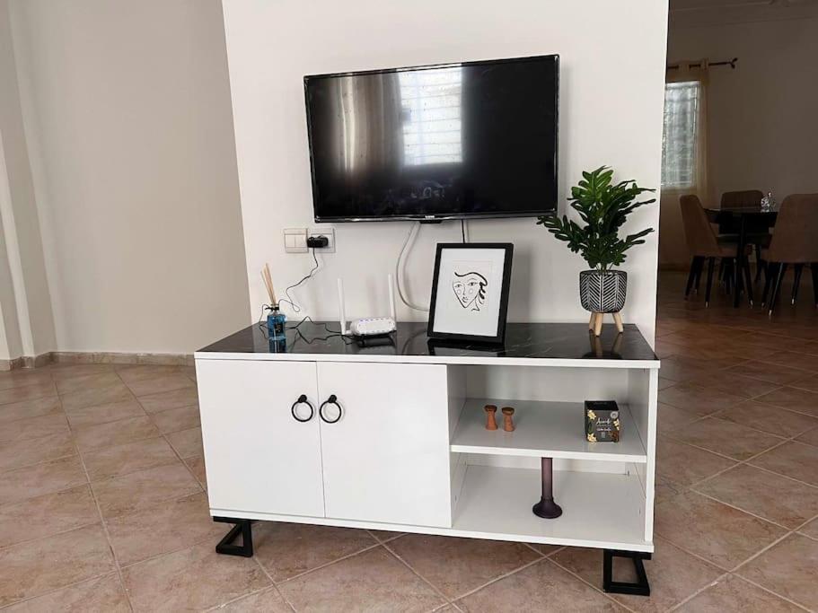 um centro de entretenimento branco com uma televisão de ecrã plano por cima em Appartement luxueux à Rabat em Rabat