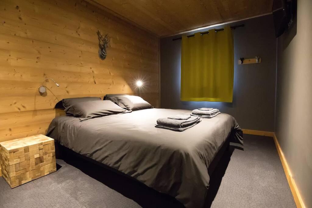 a bedroom with a large bed with a green window at HaKaJu Appartement 10 personnes à Val Cenis in Lanslebourg-Mont-Cenis