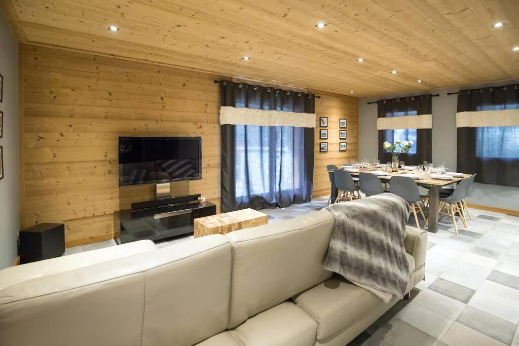 a living room with a large couch and a dining room at HaKaJu Appartement 10 personnes à Val Cenis in Lanslebourg-Mont-Cenis