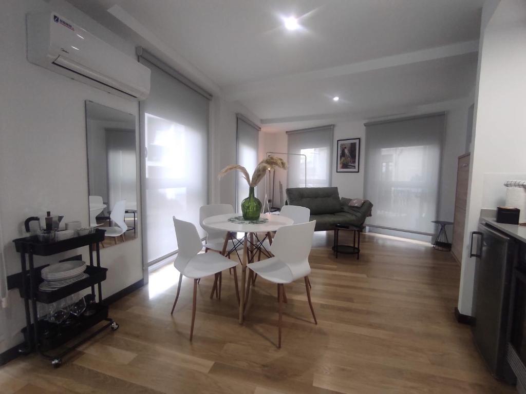 ein Wohnzimmer mit einem weißen Tisch und Stühlen in der Unterkunft 1B. Estudio muy luminoso en el corazón del tapeo. in Ourense