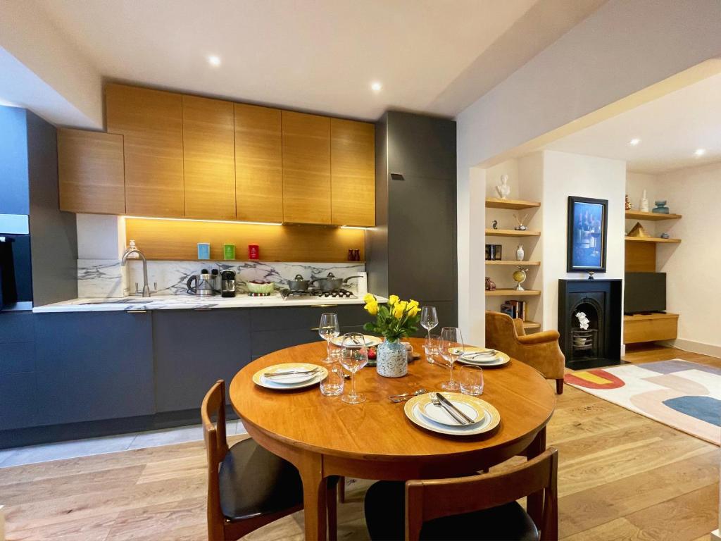 cocina y comedor con mesa de madera y sillas en Stylish 2-bedroom Townhouse next to Brighton Station, en Brighton & Hove