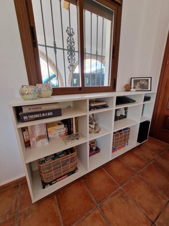 estante de libros en una habitación con ventana en B&B Casa Mijo, en Daimalos
