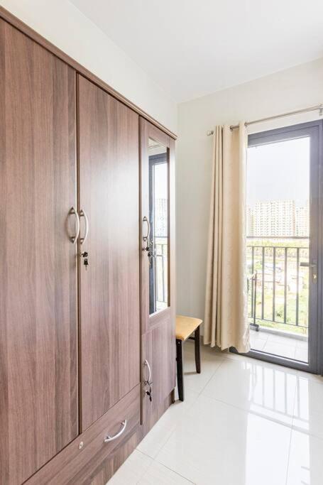 a large wooden cabinet in a room with a window at Cozy 619 1BR Shore2 Residence, Near Airport, IKEA, MOA, SMX, Pasay City, Manila in Manila