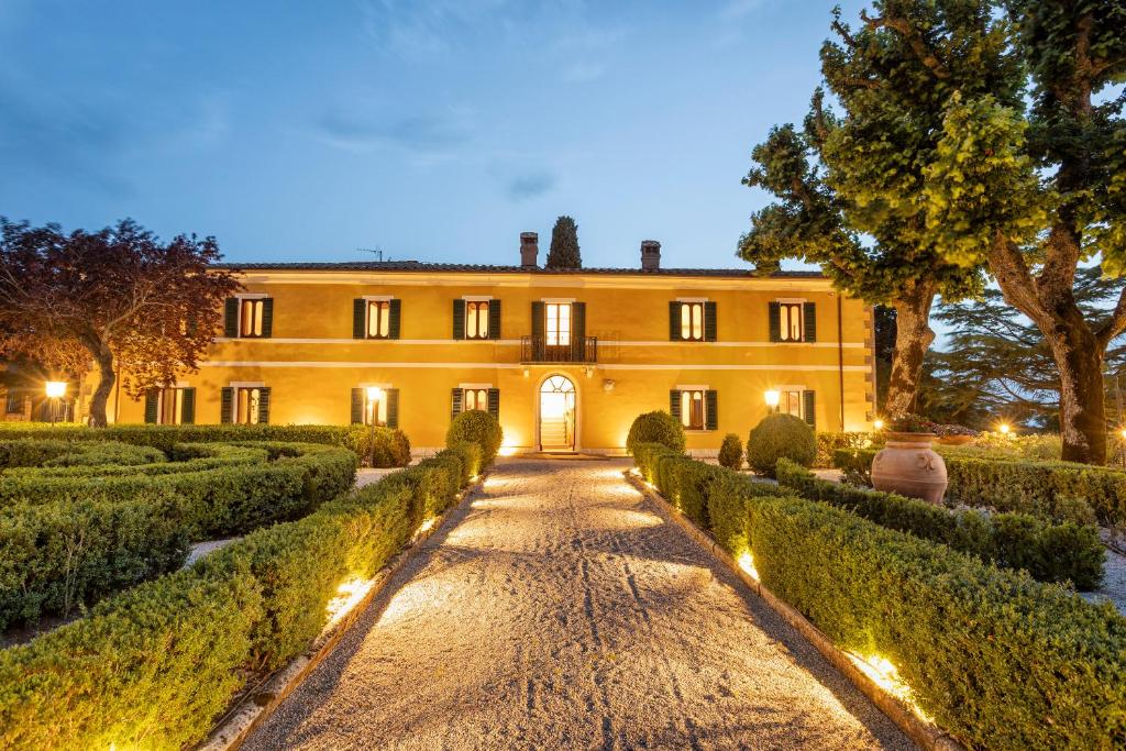 a mansion with hedges in front of a building at Villa Pianoia in Montepulciano