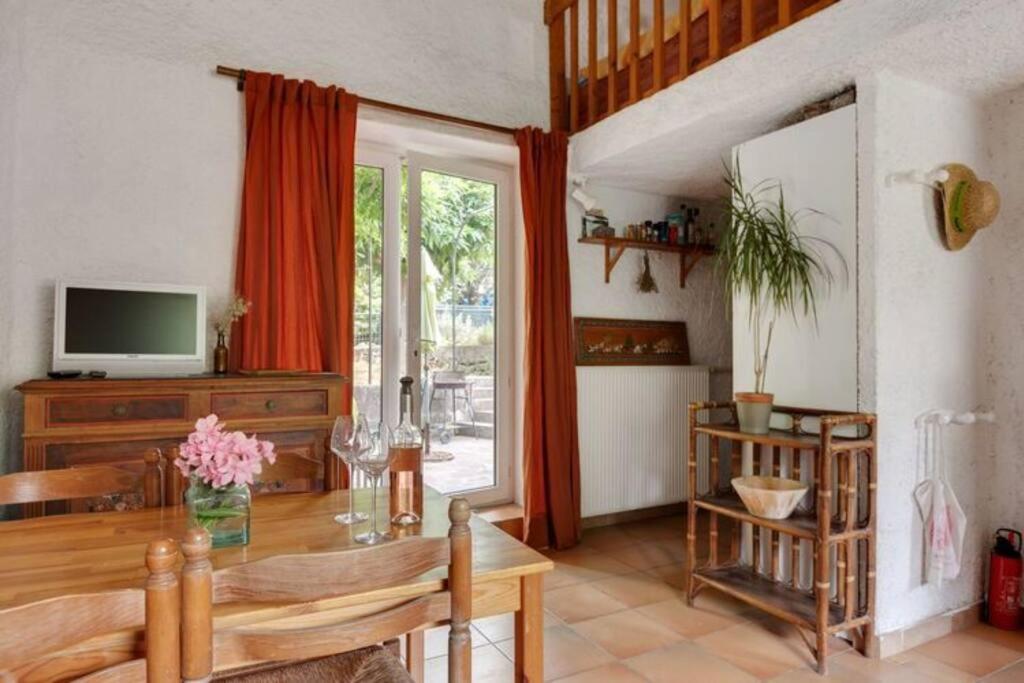 uma sala de estar com uma mesa de madeira e uma televisão em Gîte vigneron em Félines-Minervois