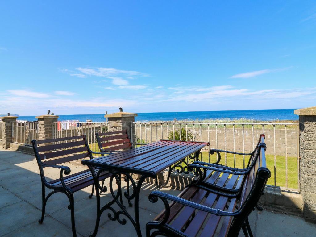 - une table de pique-nique et des chaises avec vue sur la plage dans l'établissement Shoreline House, à Fraserburgh