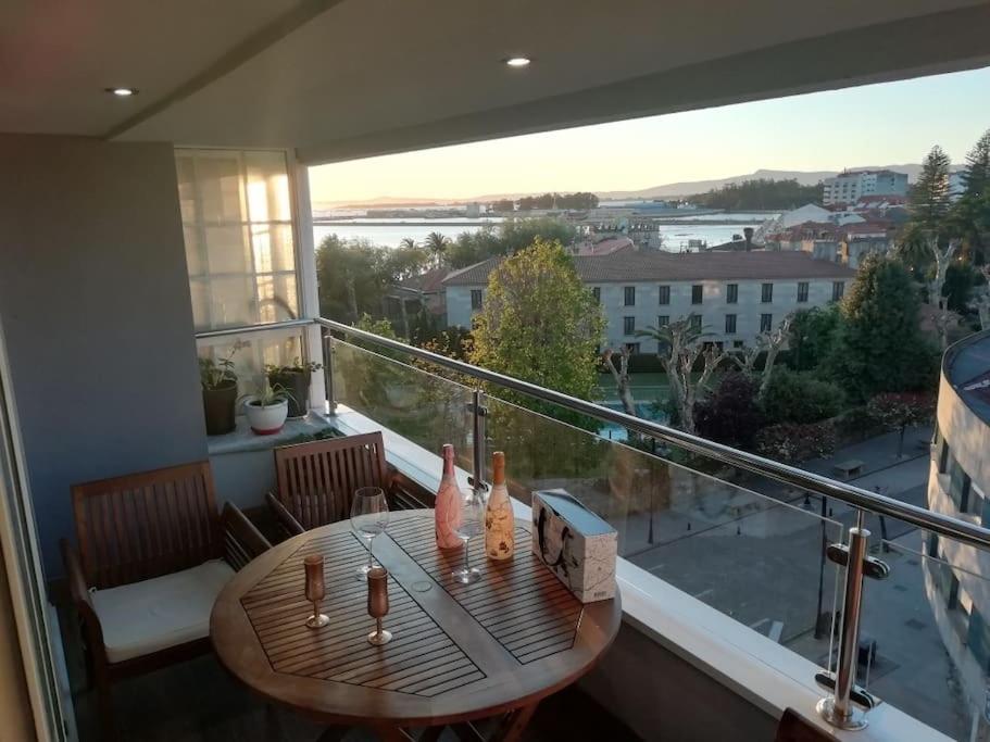 a balcony with a table and a view of a city at El mirador de Mila II en el corazón del Salnes VUT-PO-14731 in Cambados