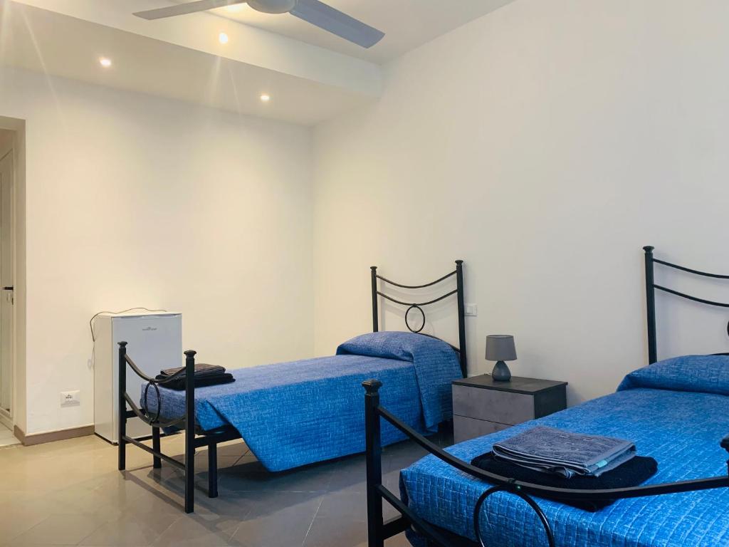 una camera con due letti con lenzuola blu di La Chiocciola a Sale