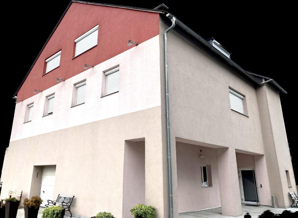 un gran edificio blanco con techo rojo en Gästehaus Leimer Bräu en Lenzing