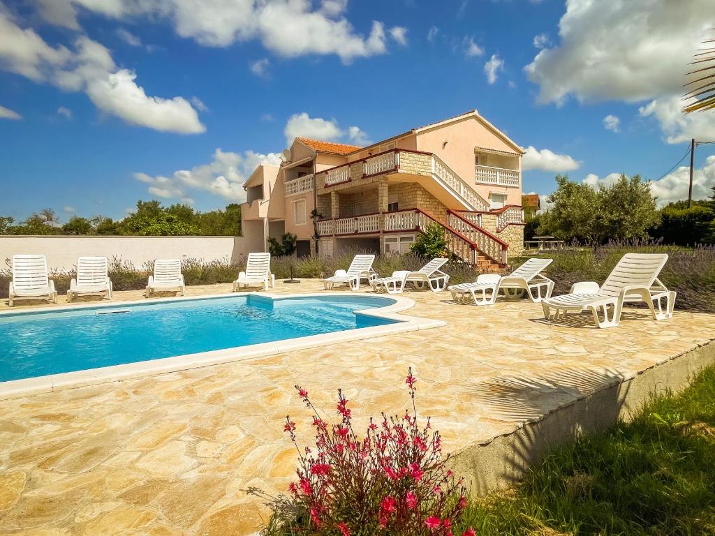 uma villa com piscina e cadeiras e uma casa em Discover Home BRMBO em Polača