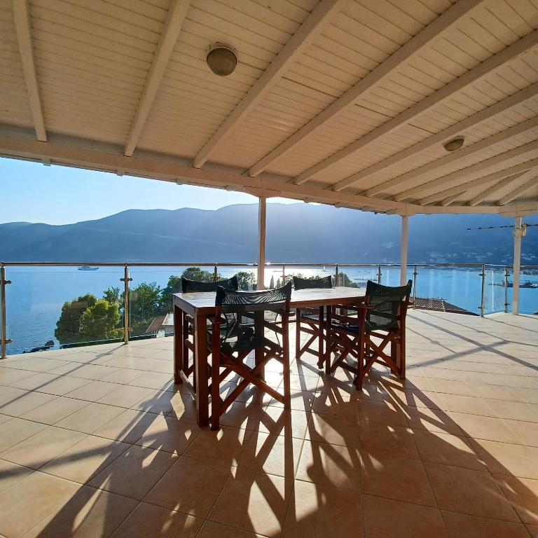 a table and chairs on a patio with a view of the ocean at Penthouse Vasiliki in Vasiliki