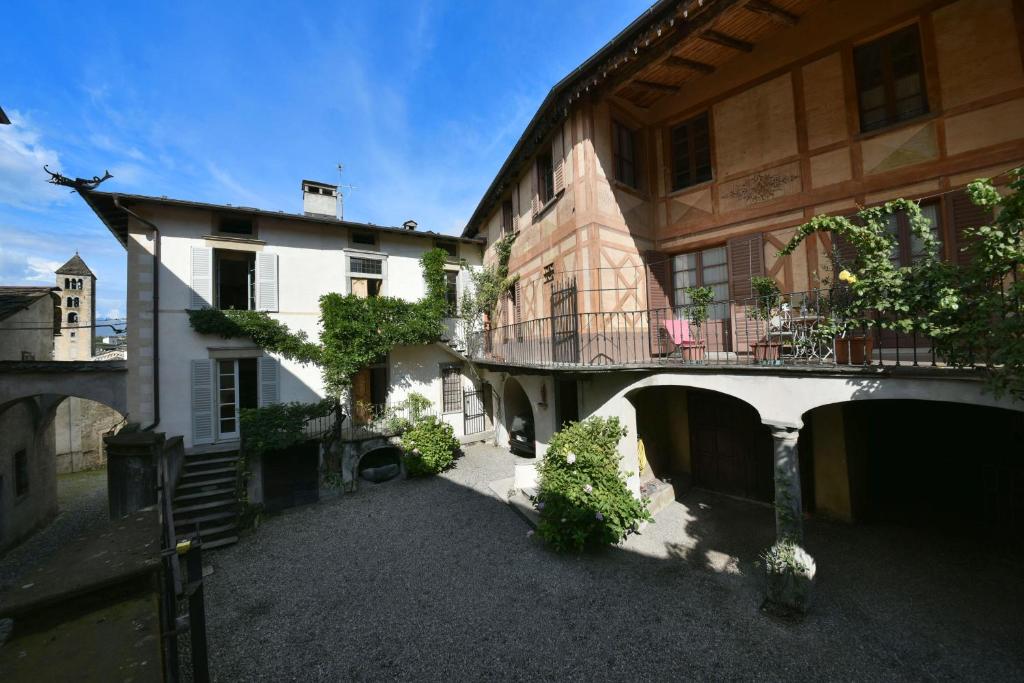 une cour vide d'un bâtiment avec un balcon dans l'établissement Piano nobile al Roseto del Drago, à San Bernardo