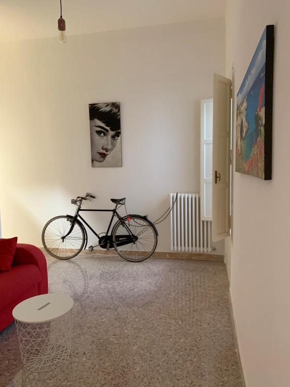 una bicicletta in soggiorno con divano rosso di CONTINOWINES a Lequile