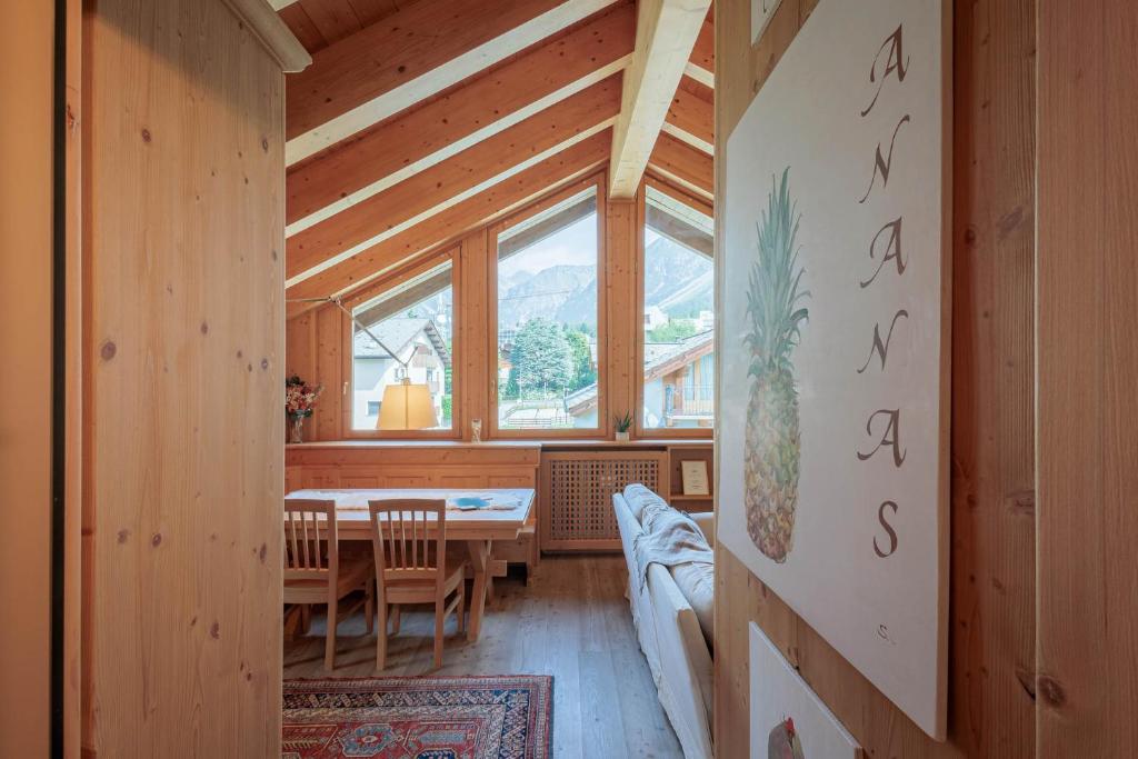 une salle à manger avec une table et des chaises et une fenêtre dans l'établissement REVO Apartments - Santa Barbara1, à Bormio