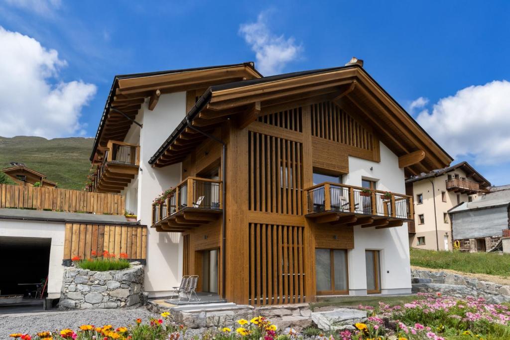 uma casa nas montanhas com uma varanda em Arion Apartments - Trepalle em Livigno