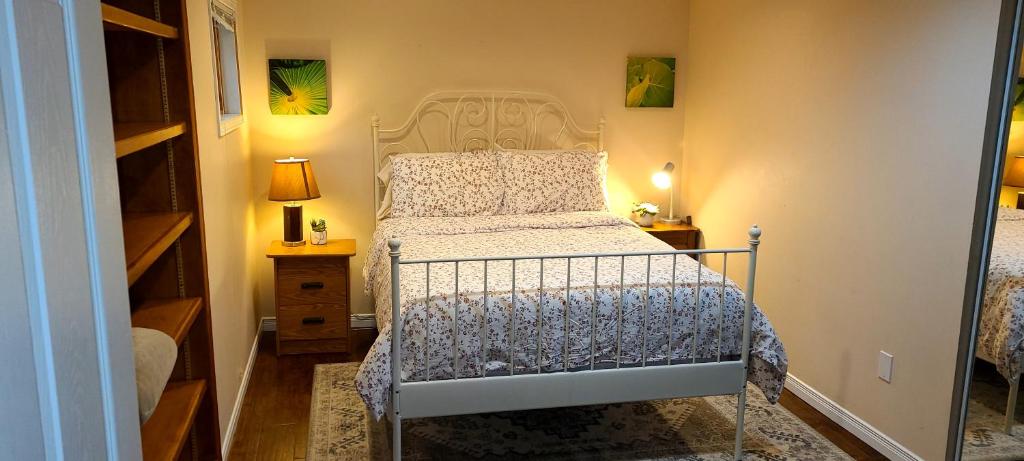 1 dormitorio pequeño con 1 cama y 2 mesitas de noche en Spacious and bright unit with natural light., en Pickering