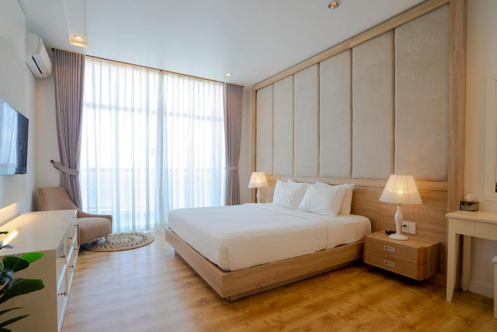 Cette chambre comprend un lit et une grande fenêtre. dans l'établissement Ocean View Studio,Ocean View 3BR-apartment, Sealinks City, Mui Ne, à Phan Thiết