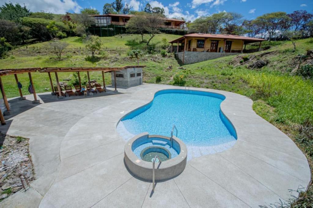 a swimming pool in a patio with a house at Vilcabamba casa / granja Vilcabamba house / farm in Loja