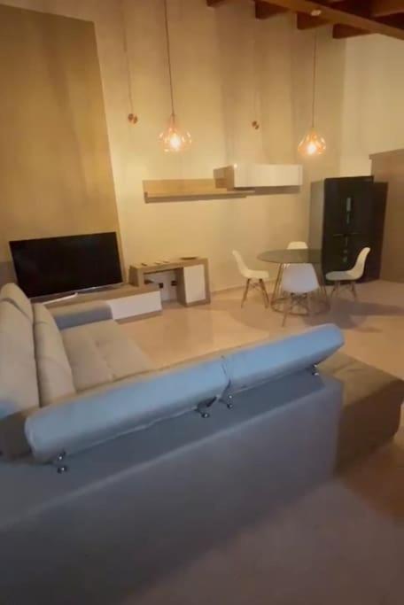 a living room with a couch and a table and chairs at Appartamento moderno con 2 camere grandi e lavanderia in Brescello