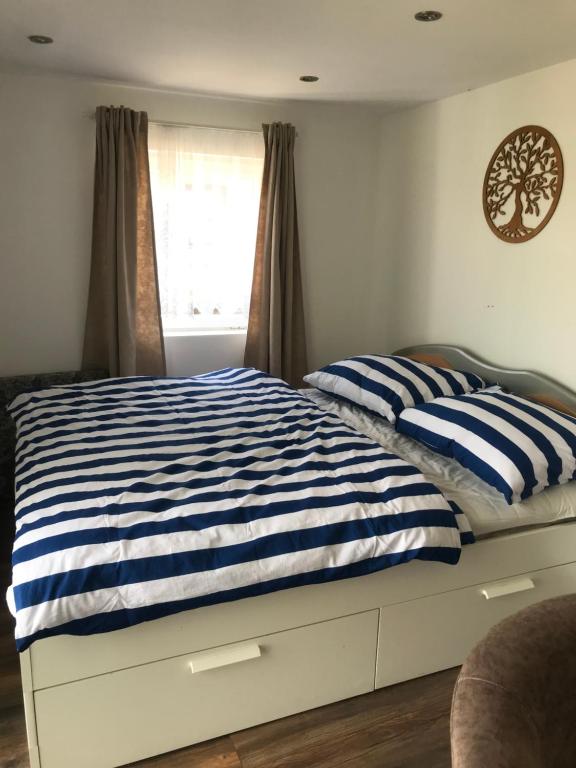 een slaapkamer met een bed met blauwe en witte strepen bij Vila Juliana in Kostol