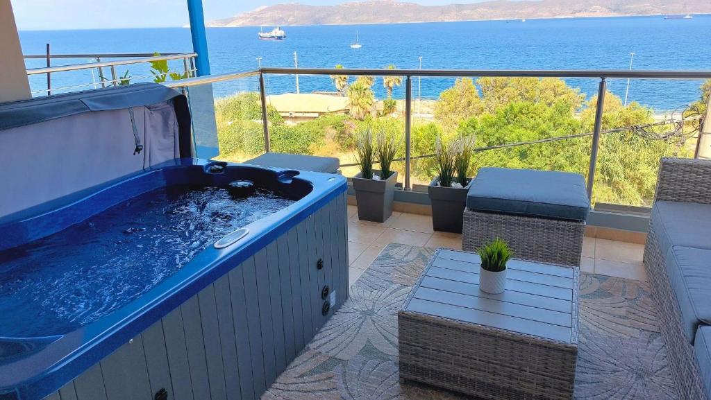 a hot tub on a balcony with a view of the ocean at PORTO D'ORO LUXURY APARTMENT in Lavrio