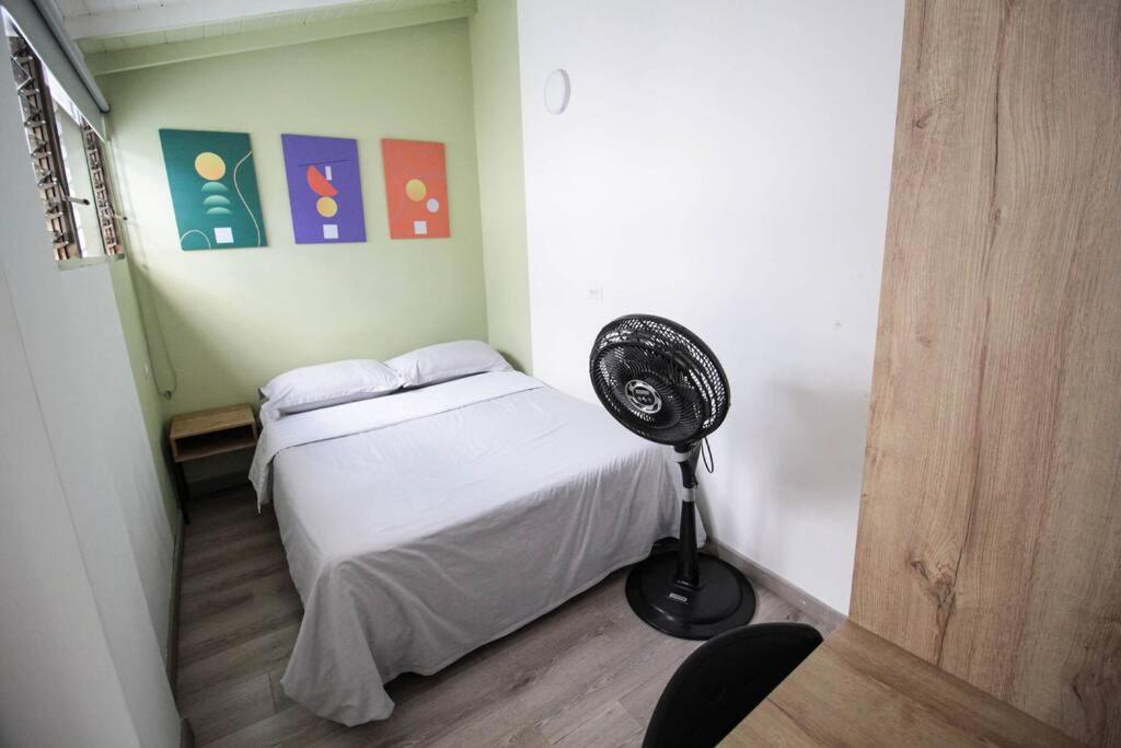 une chambre avec un lit et un ventilateur dans l'établissement Hospedaje privado cerca a Provenza en el Poblado - M301 By Roots Rentals, à Medellín