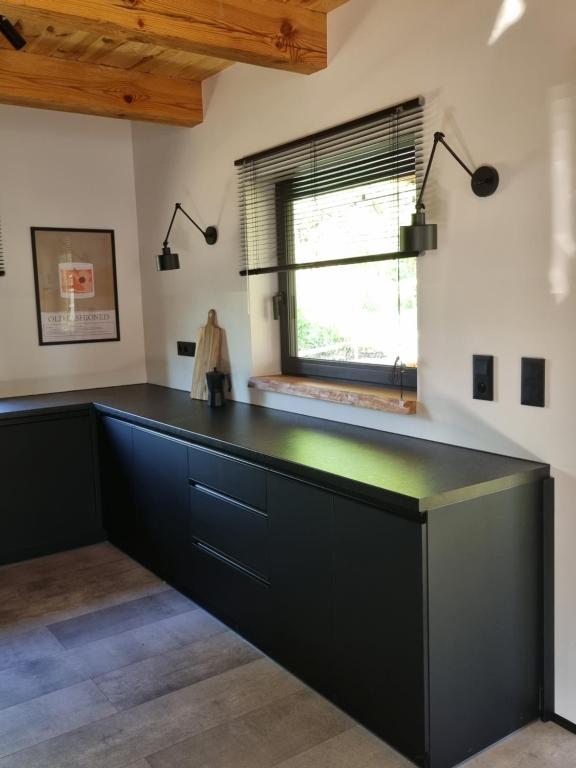 a large black counter in a room with a window at Sosnowy Plan in Józefów