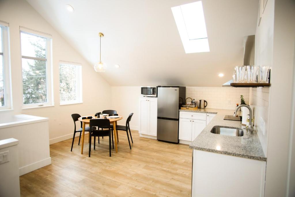 uma cozinha com uma mesa e um frigorífico em Life Elevated Loft: Bright, Prime Location + SAUNA em Salt Lake City