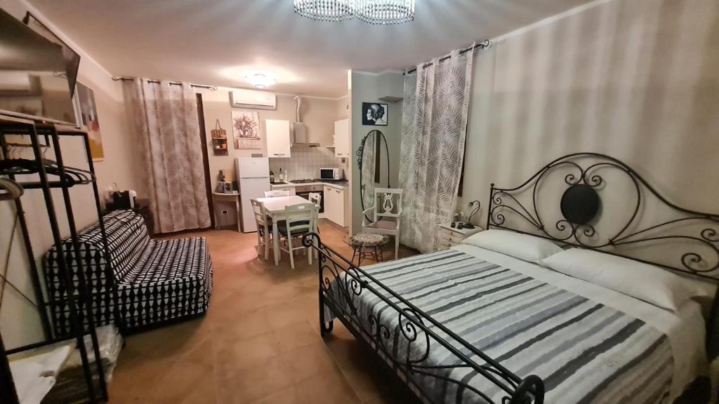 um quarto com uma cama e uma cadeira e uma cozinha em La Torre em Castiglion Fiorentino