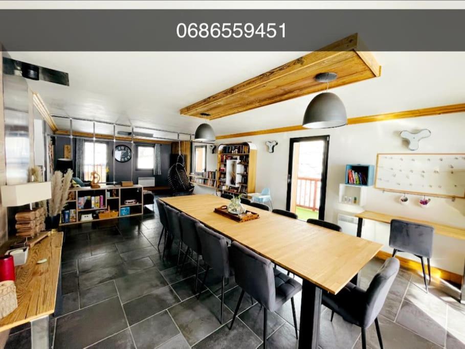une salle à manger avec une grande table et des chaises en bois dans l'établissement Beaver Creek appartement 12 Personnes à Val Cenis, à Lanslebourg-Mont-Cenis