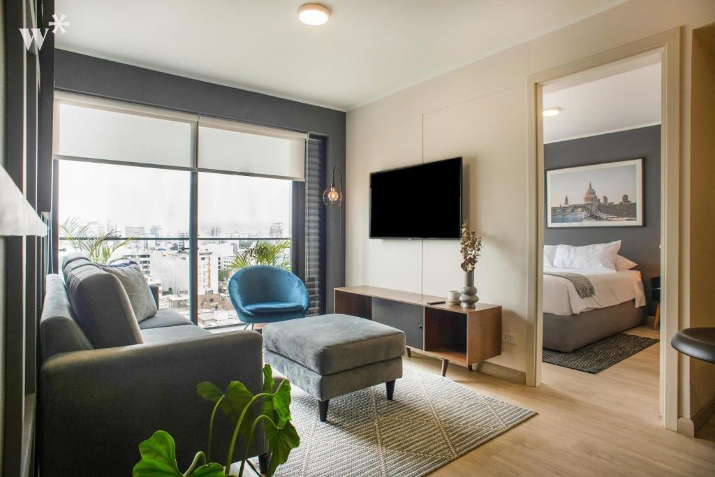a hotel room with a bed and a television at El Sol Living in Barranco by Wynwood House in Lima