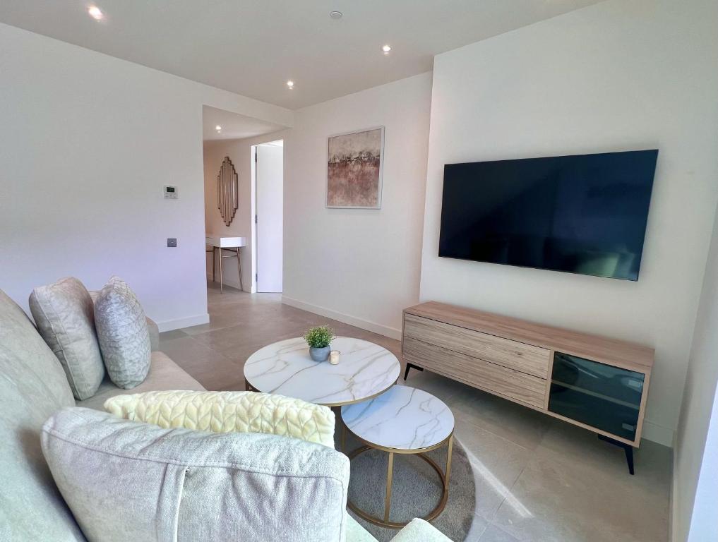 uma sala de estar com um sofá e uma grande televisão de ecrã plano em Luxury 1 Bed Apt With Pool Access In Eurocity em Gibraltar