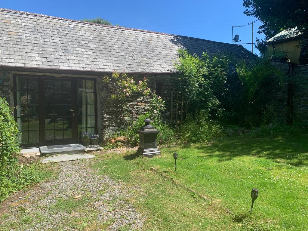 a house with a garden with a birdbath in the yard at Downrow Barn in Tintagel