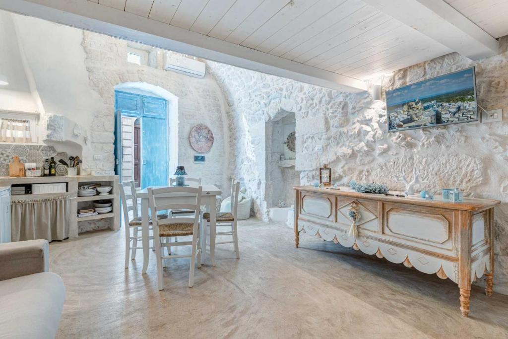 eine Küche und ein Esszimmer mit einer Steinmauer in der Unterkunft Bianco Calce - Ostuni in Ostuni