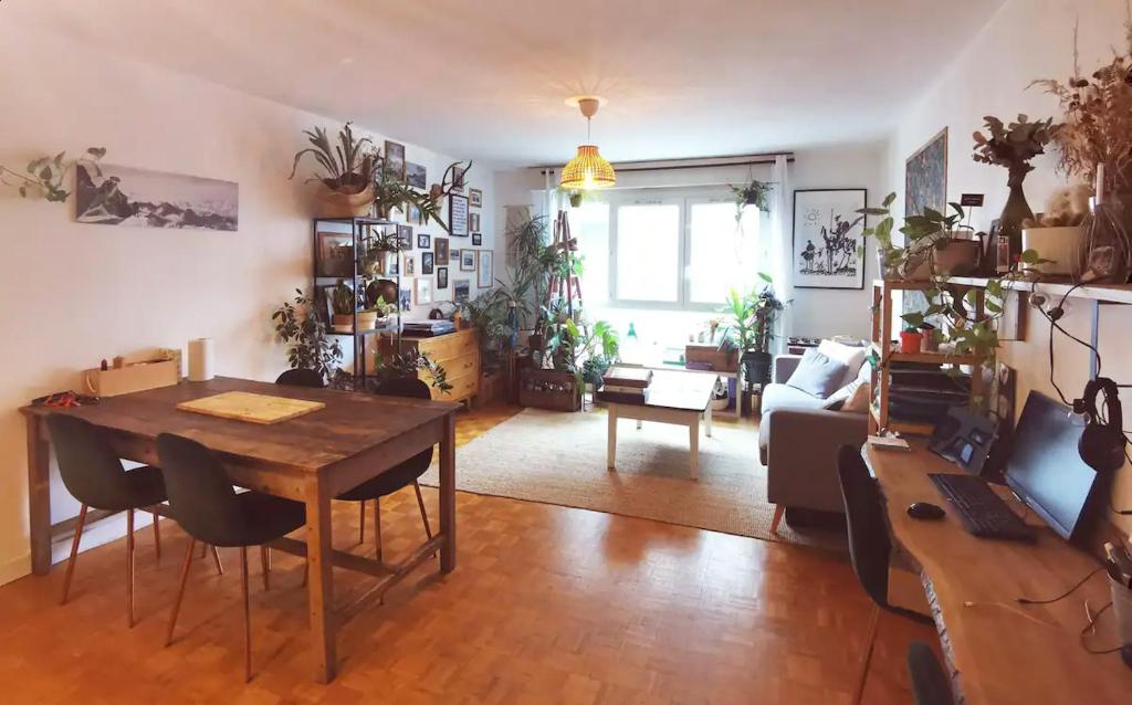 een woonkamer met een tafel en een bank bij Appartement familial Coeur 7 ème in Lyon