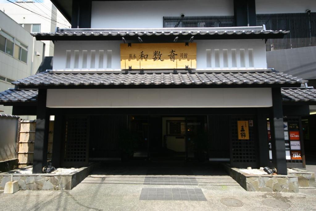 une entrée à un bâtiment avec écriture sur celui-ci dans l'établissement Wasuki Tsukasakan, à Kumamoto