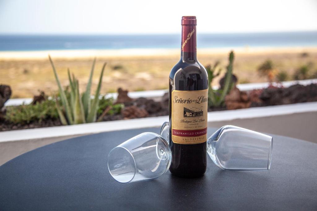 una bottiglia di vino e bicchieri seduti su un tavolo di Amazing Luxury Apartment, La Casa del Corazon a Morro del Jable