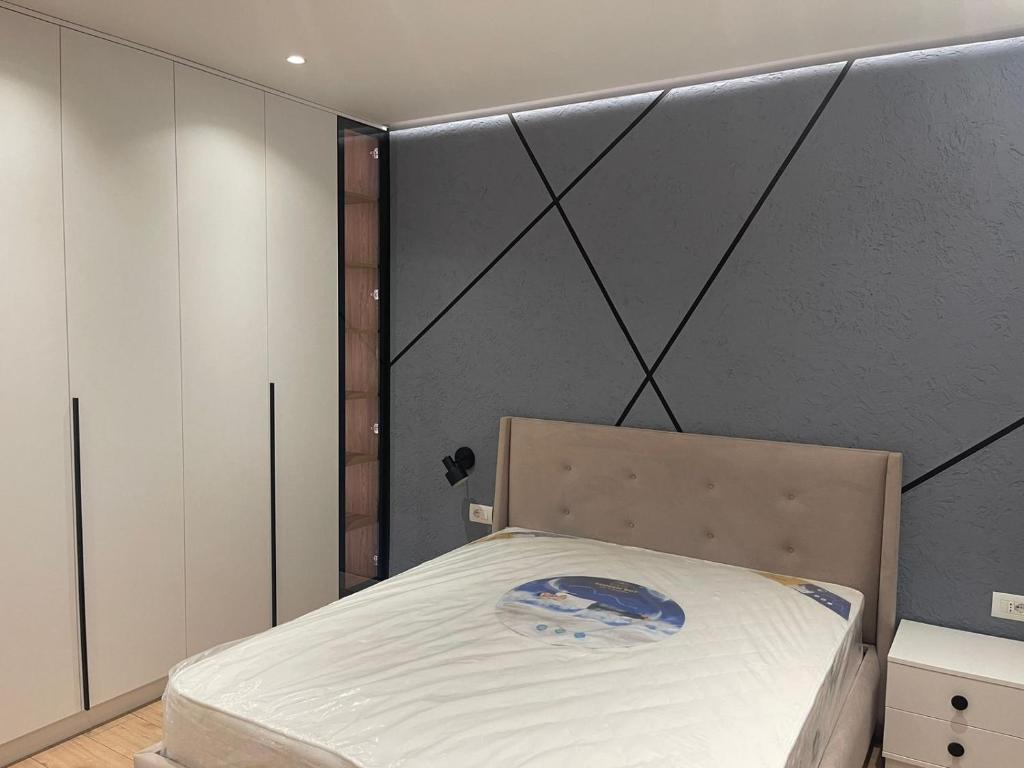 1 dormitorio con 1 cama en una habitación con pared en Emi Apartment, en Durrës