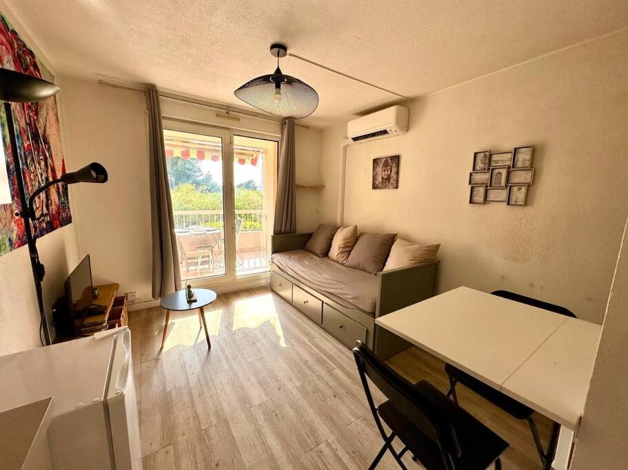 un salon avec un canapé et une table dans l'établissement Studio avec piscine proche du centre et de la gare, à Sanary-sur-Mer