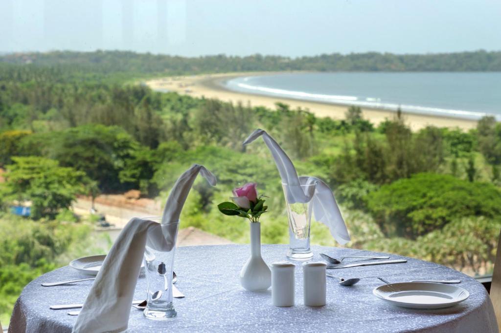 a table with utensils and a flower on top of it at Varanda Do Mar in Panaji