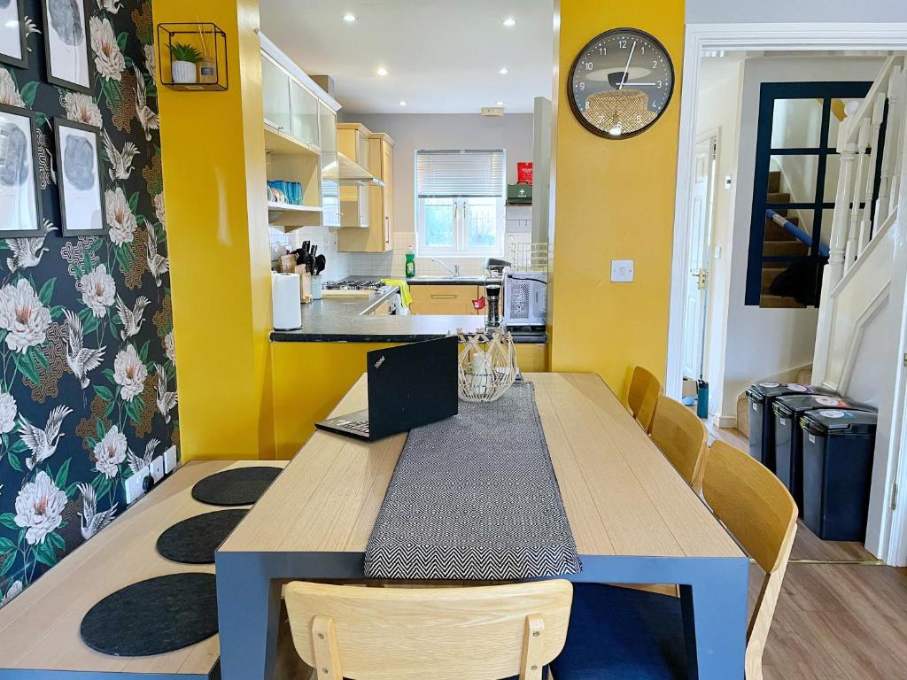 a kitchen with a wooden table and yellow walls at Mayflower House Barnsley-Wombwell-3 Bedrooms-2 Showers-Longer Stay- Free Parking in Barnsley
